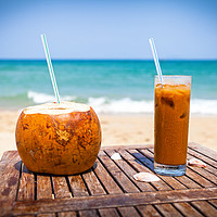 Buy canvas prints of Coconut drink and ice coffee on the wooden table by Łukasz Szczepański