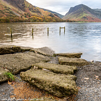 Buy canvas prints of Stones n the Edge of Lake Buttermere in the Lake District in Cumbria, England by Dave Collins