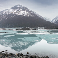 Buy canvas prints of Snow covered mountains reflected between the ice sheets in Valdez Glacier Lake, Valdez, Alaska, USA by Dave Collins