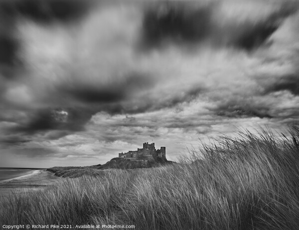 Gathering storm over Bamburgh Castle Picture Board by Richard Pike