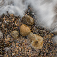 Buy canvas prints of Pebbles being washed over by the incoming tide. by Bryn Morgan