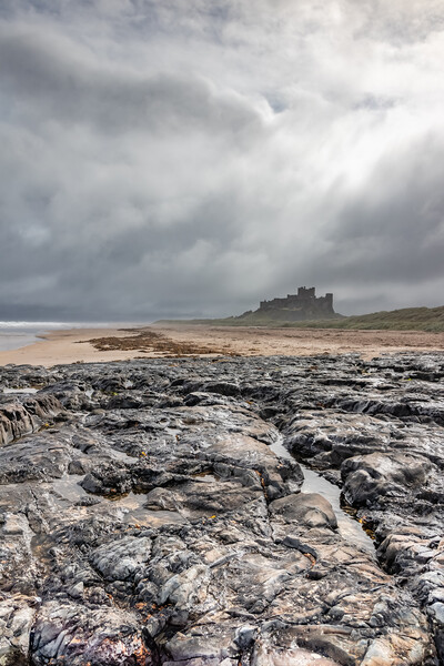 Majestic Bamburgh Castle Amidst a Stormy Sky Picture Board by James Marsden