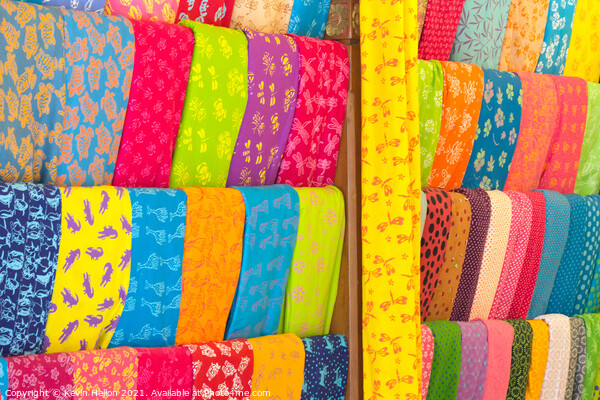 Bolts of colourful cloth hanging in a shop in Denpasar, Bali, In Picture Board by Kevin Hellon