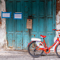 Buy canvas prints of Red bicycle parked by blue doors by Kevin Hellon