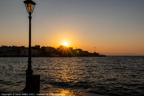 Sun setting over the Venetian Harbour, Chania Picture Board by Kevin Hellon