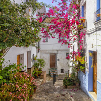 Buy canvas prints of Narrow, hilly street in Ubrique by Kevin Hellon