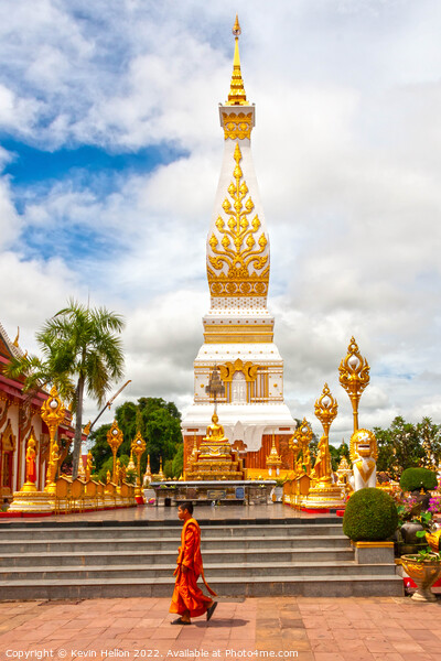 A monml walks past the spire in Wat Phra That Phanom Picture Board by Kevin Hellon