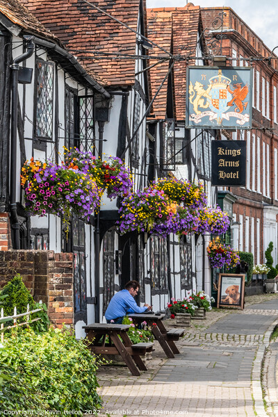 A man sits outside the Kings Arms Hotel in Amersham old town Picture Board by Kevin Hellon