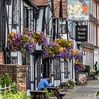 Buy canvas prints of A man sits outside the Kings Arms Hotel in Amersham old town by Kevin Hellon