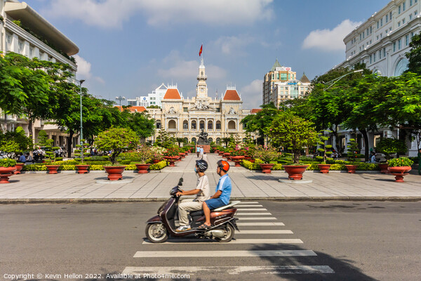A motorcyclist rides along the road.past a statue of Ho Chi Minh Picture Board by Kevin Hellon