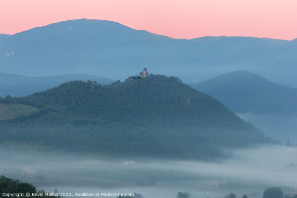 Hilltop castle surrounded by early morning mist Picture Board by Kevin Hellon
