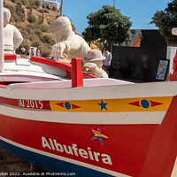 Buy canvas prints of Boat and stone statues, Albufeira old town, by Kevin Hellon