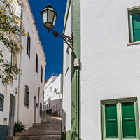 Buy canvas prints of Narrow, steep street, Albufeira old town, by Kevin Hellon