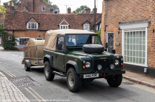 Landrover Defender pulling truck with a bale of hay, Picture Board by Kevin Hellon