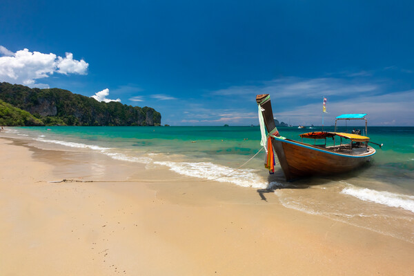 Long tail boat moored at Ao Nang Beach Picture Board by Kevin Hellon