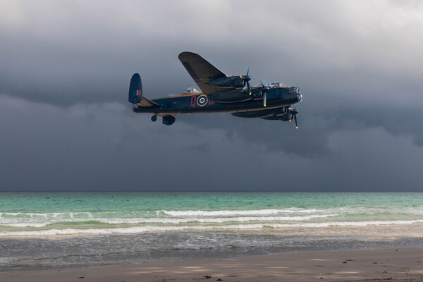 Lancaster bomber over the sea and under a dark, cloudy sky Picture Board by Kevin Hellon