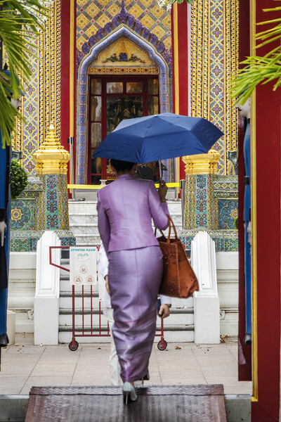 Thai Woman with Umbrella at Wat Ratchabophit Picture Board by Kevin Hellon