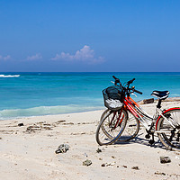 Buy canvas prints of Bicycles on a white sand beach by Kevin Hellon