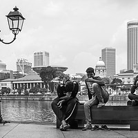 Buy canvas prints of Three men sat on a bench on Boat Quay, Singapore  by Kevin Hellon