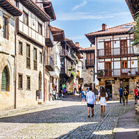Buy canvas prints of Tourists walking around the town in Santillana, Sp by Kevin Hellon