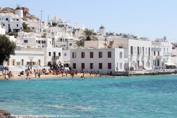 Tourists relaxing on the beach in Chora, Mykonos,  Picture Board by Kevin Hellon
