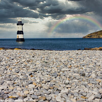 Buy canvas prints of Penmon lighthouse and shingle beach with rainbow by Kevin Hellon