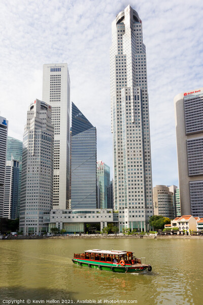 Bumboat on the Singapore river with the tall buildings of the fi Picture Board by Kevin Hellon