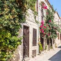 Buy canvas prints of Stone houses covered with bougainvillaea, by Kevin Hellon