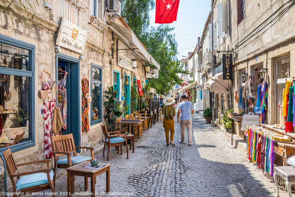 Couple walking down a narrow street Picture Board by Kevin Hellon