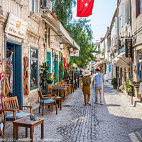 Buy canvas prints of Couple walking down a narrow street by Kevin Hellon