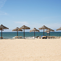 Buy canvas prints of tropical parasols on the algarve beach by Chris Willemsen