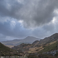 Buy canvas prints of Moody and dramatic Winter landscape image of Moel Saibod from Crimpiau in Snowdonia with stunning shafts of light in stormy weather by Matthew Gibson