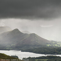 Buy canvas prints of Stunning epic landscape image across Derwentwater valley with falling rain drifting across the mountains causing pokcets of light and dark across the countryside by Matthew Gibson