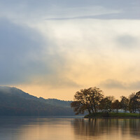 Buy canvas prints of Stuning Autumn Fall sunrise landscape over Coniston Water with mist and wispy clouds by Matthew Gibson