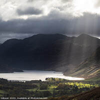 Buy canvas prints of Majestic sun beams light up Crummock Water in epic Autumn Fall landscape image with Mellbreak and Grasmoor  by Matthew Gibson