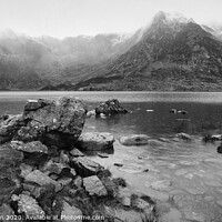 Buy canvas prints of Beautiful moody Winter landscape image of Llyn Idwal and snowcapped Glyders Mountain Range in Snowdonia in black and white by Matthew Gibson