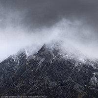 Buy canvas prints of Stunning detail landscape images of snowcapped Pen Yr Ole Wen mountain in Snowdonia during dramatic moody Winter storm by Matthew Gibson