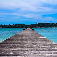 Buy canvas prints of Wooden pier leading out to the sea by  
