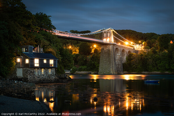 Menai Bridge glowing in the straits Picture Board by Karl McCarthy