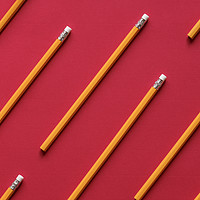 Buy canvas prints of Yellow wooden pencil on red background by Daniela Simona Temneanu