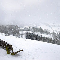 Buy canvas prints of Wooden bench on a hill and snowfall by Daniela Simona Temneanu