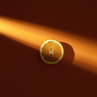 Buy canvas prints of Orange slice in sunlight. Fresh slice of orange. Minimal image by Daniela Simona Temneanu