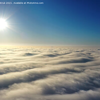 Buy canvas prints of Aerial view, bright sun above the horizon and over dense wavy gray clouds against a deep blue sky. by Sergii Petruk