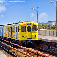 Buy canvas prints of A bright yellow metro train departs from the platform and rushes along the metro bridge in Kyiv to the left side of the city. by Sergii Petruk