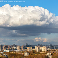Buy canvas prints of A large white-gray cloud hung over the city and was illuminated by the spring sunbeams. by Sergii Petruk