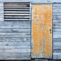 Buy canvas prints of Wooden old weather-beaten barn with a yellow old door by Sergii Petruk