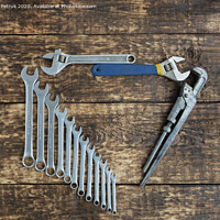 Buy canvas prints of Set of combination wrenches and old adjustable wrenches on an old wooden background by Sergii Petruk