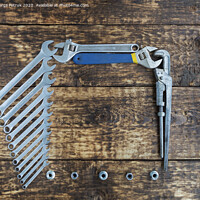 Buy canvas prints of Set of combination wrenches and old adjustable wrenches on an old wooden background by Sergii Petruk