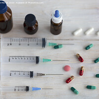 Buy canvas prints of Syringes and capsules, medical ampoules and tablets on a white wooden table. by Sergii Petruk