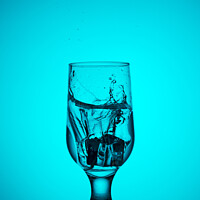 Buy canvas prints of An ice cube falls into a glass glass with water by Sergii Petruk